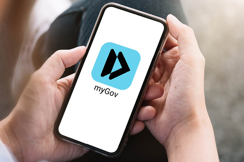 Close up of a phone held in two hands with the myGov app showing on the screen
